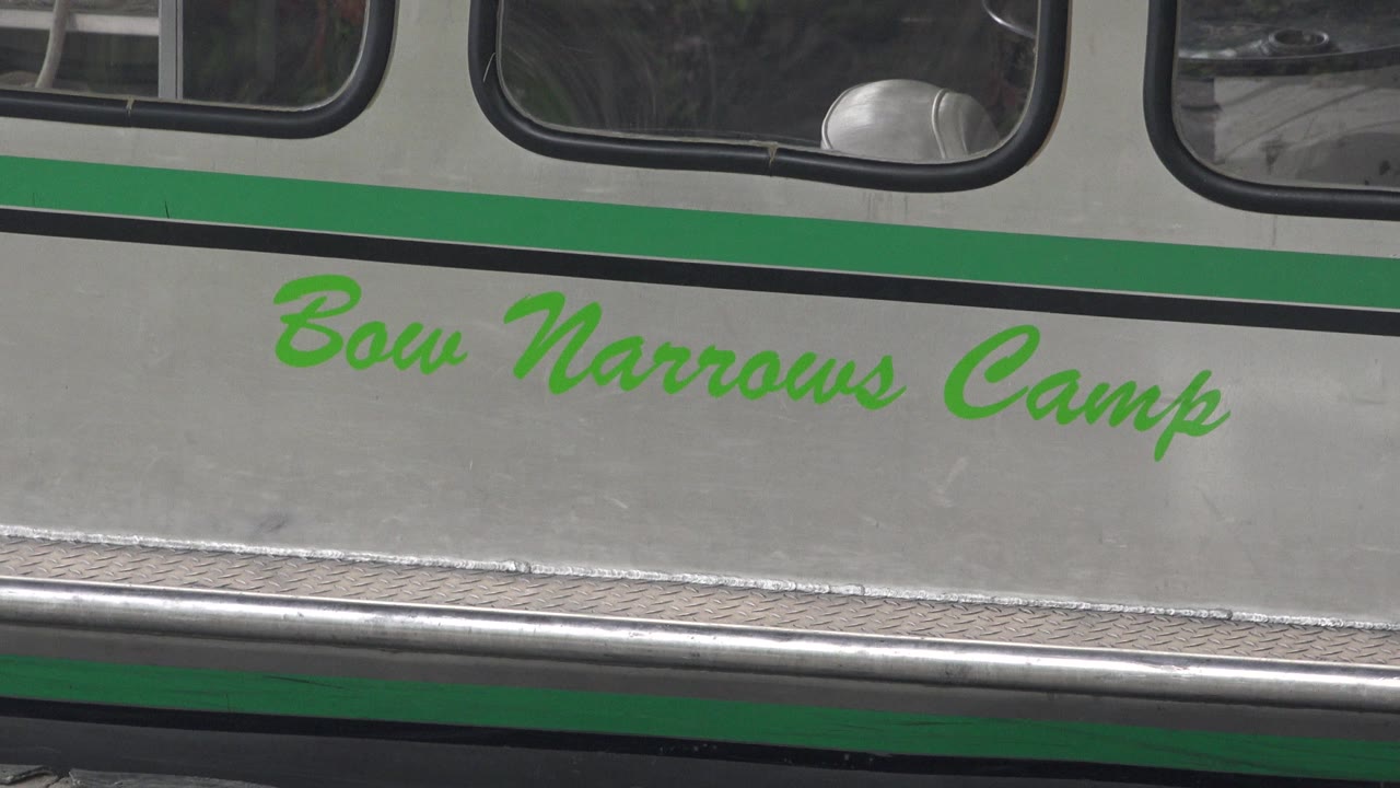 A tight Red Lake, Canada view keeps the Bow Narrows Camp text centered on the silver and green boat side, with dark cabin windows and no visible people.