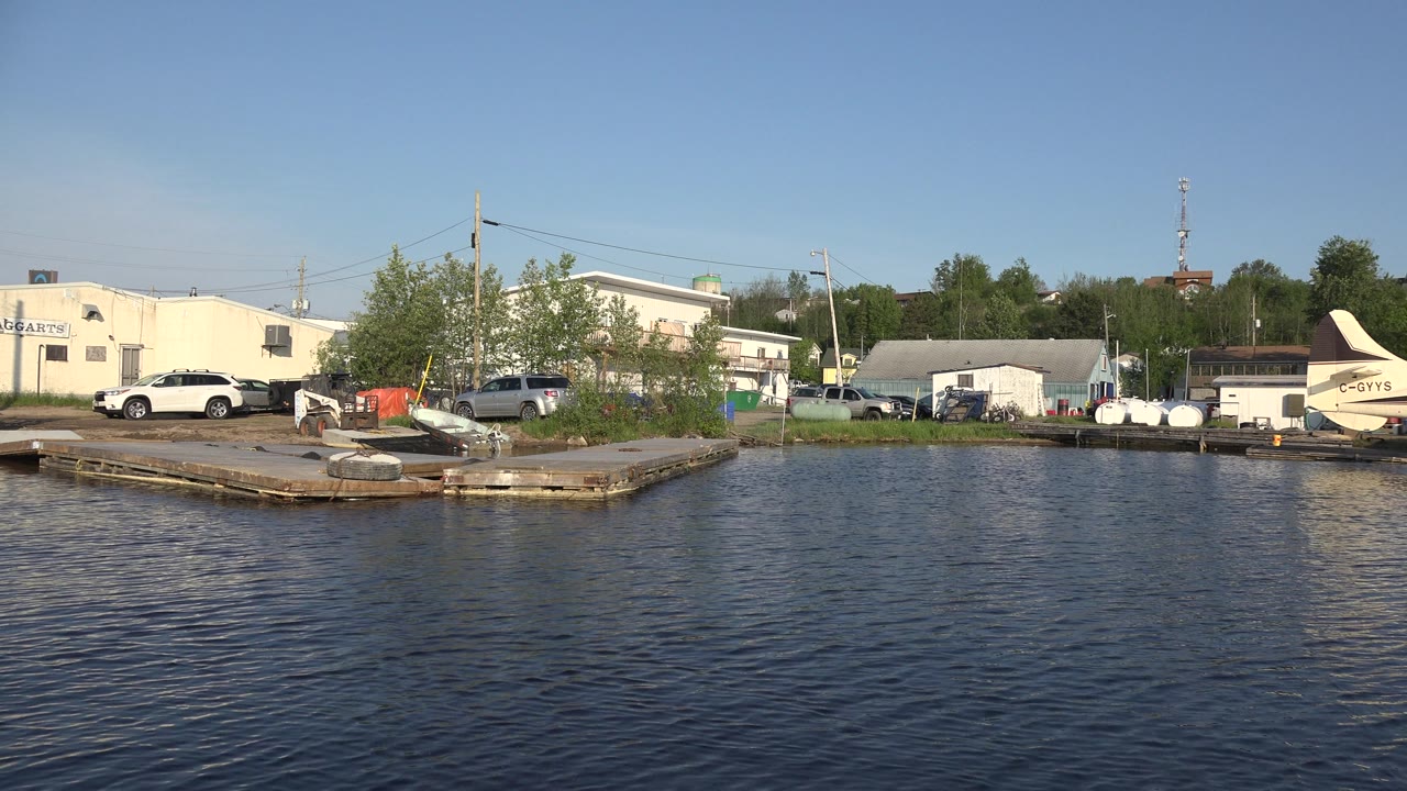 Shoreline buildings with parked cars and part of a seaplane