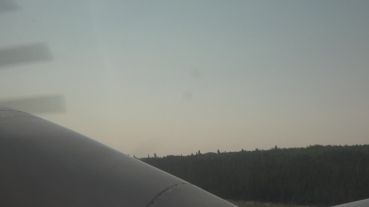 Propeller blur above plane foreground and distant trees