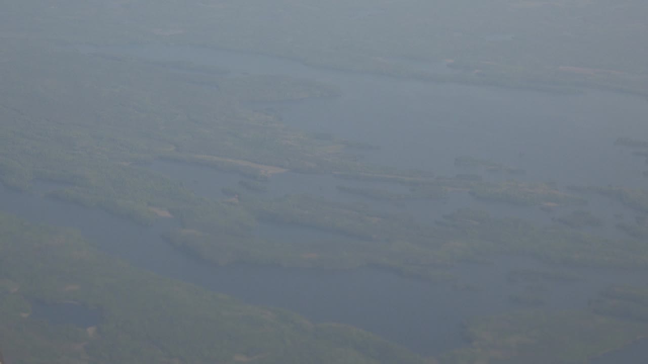 A hazy view from above Red Lake, Canada, showing branching lake shapes, low-contrast forest, and no visible people or structures.