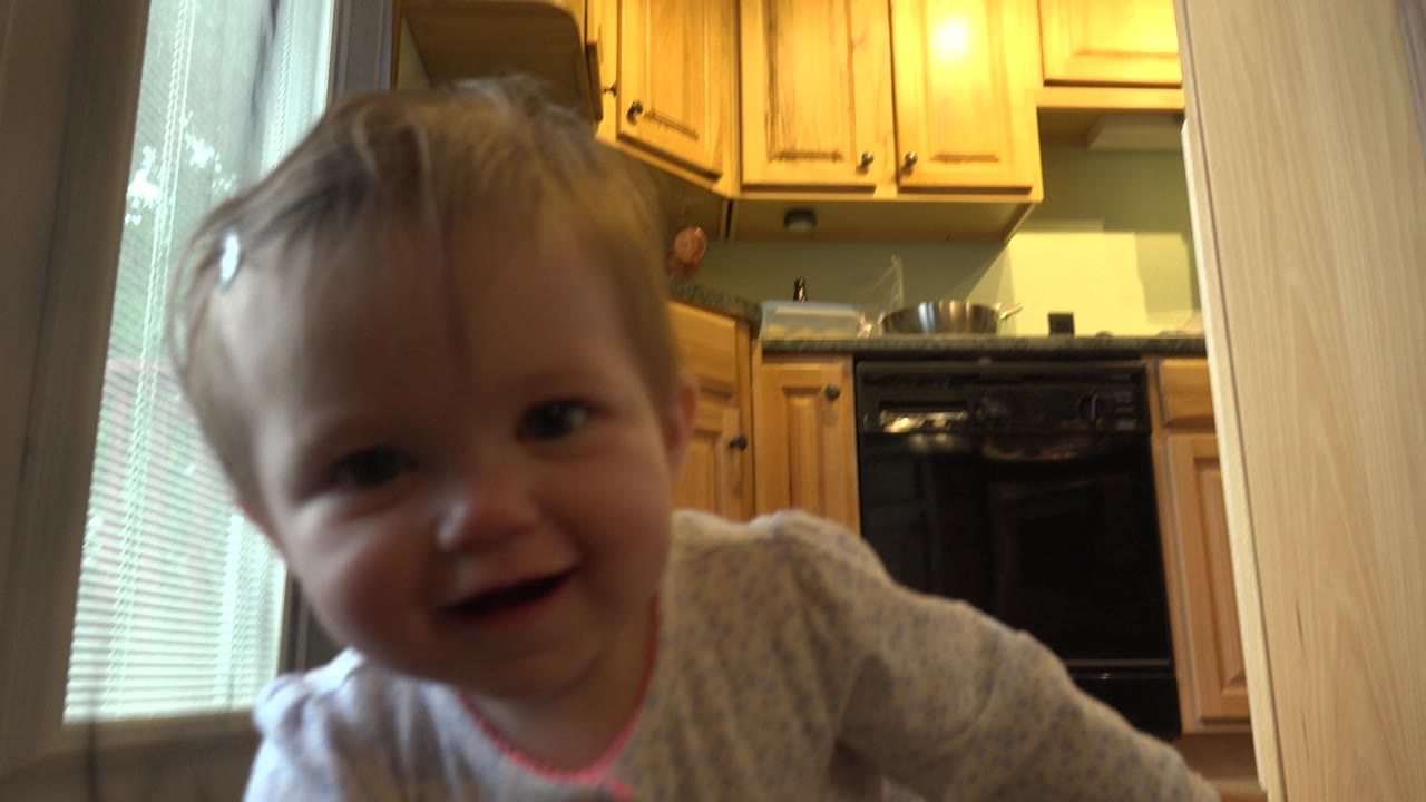 Baby close to the camera on a kitchen floor.