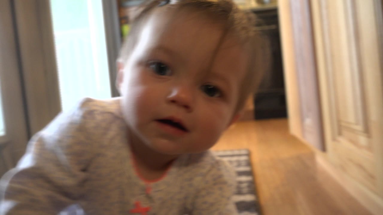 Toddler close to the camera inside a home doorway.