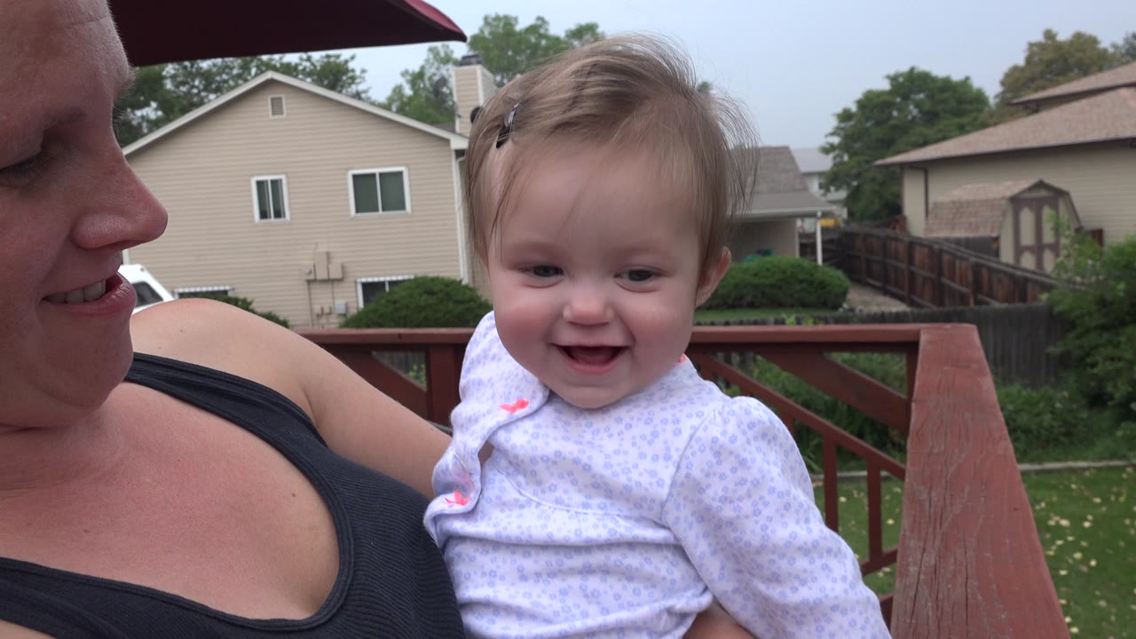 In Westminster, Colorado, the baby smiles toward the camera while the mother looks down from the left edge of the close deck shot.