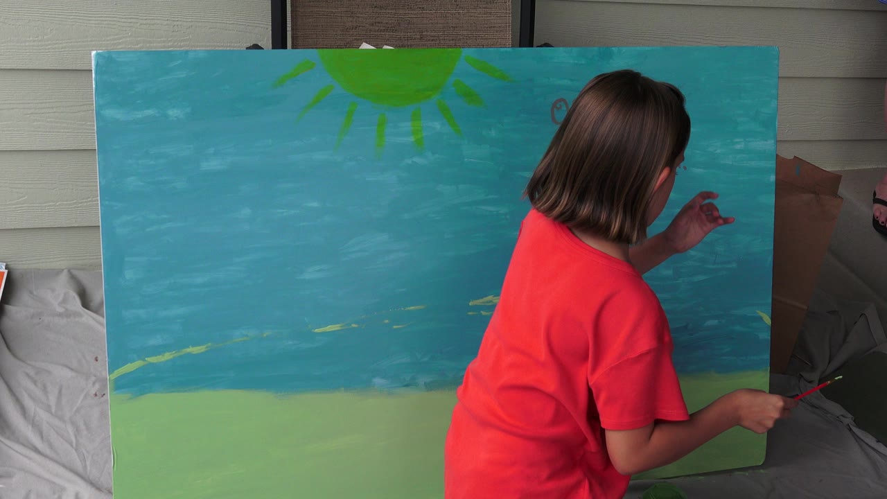 Female in an orange shirt painting a large blue and green canvas.