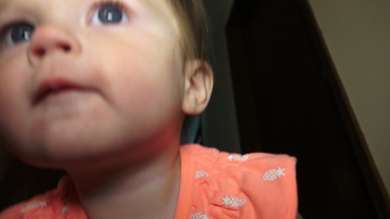 Toddler face very close to the camera lens.