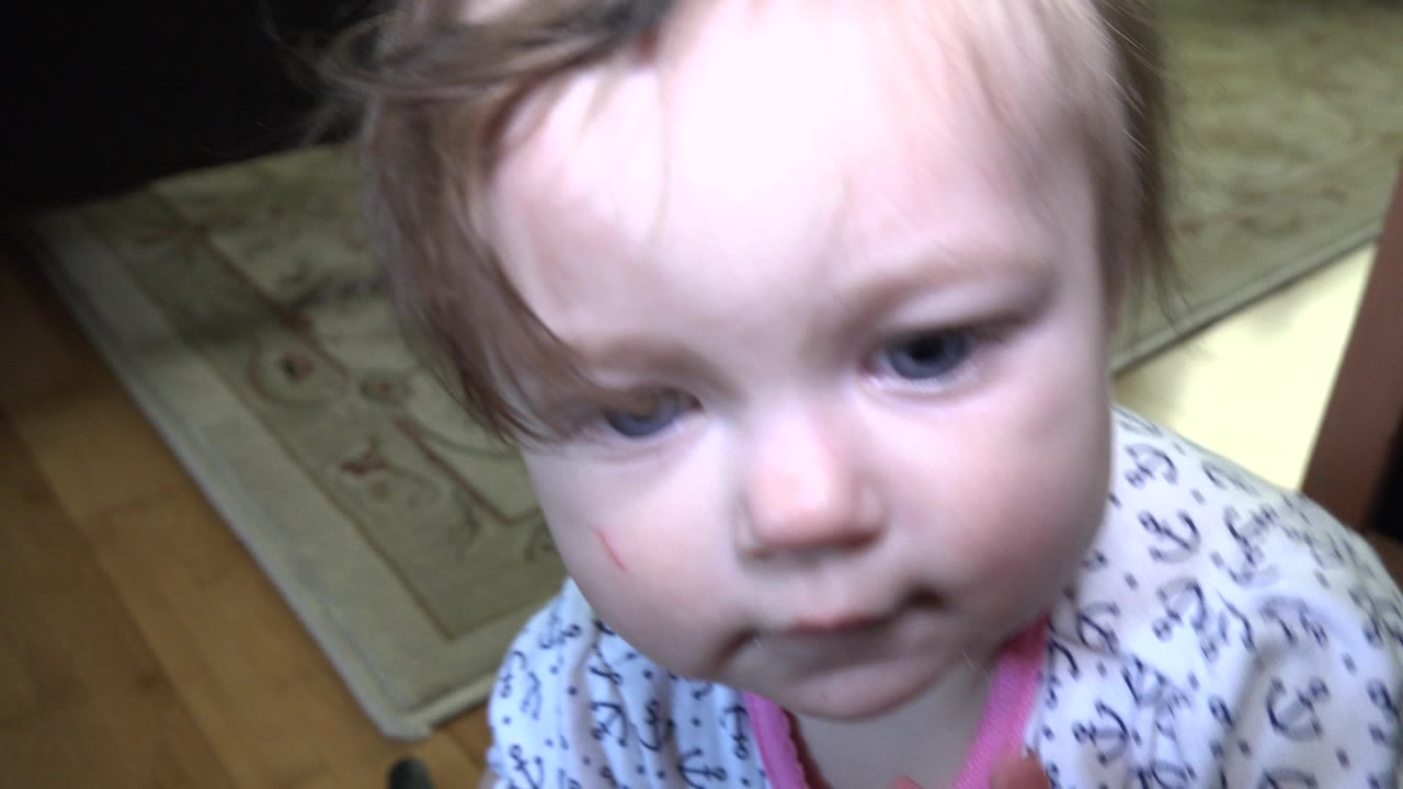 Baby close to a low camera on an indoor floor.