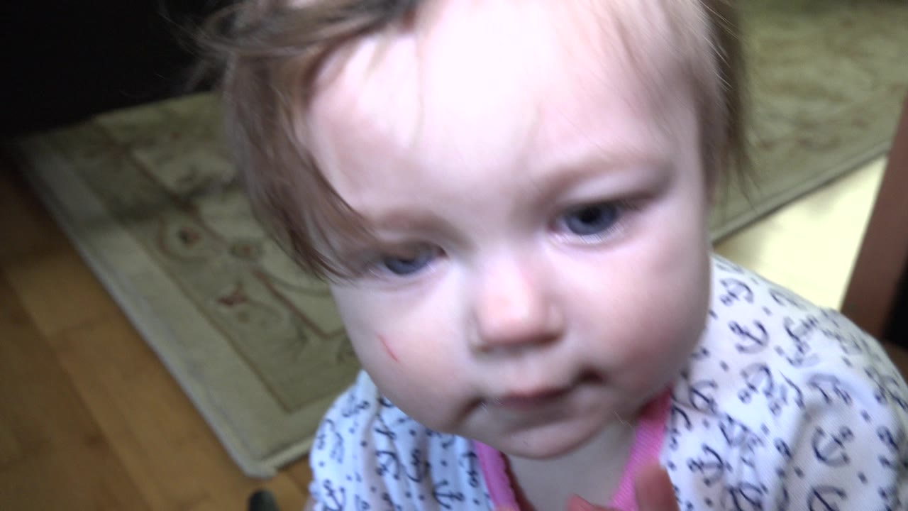 The baby remains close to the lens in the Westminster, Colorado home, looking slightly downward as the wood floor and patterned rug stay in the background.