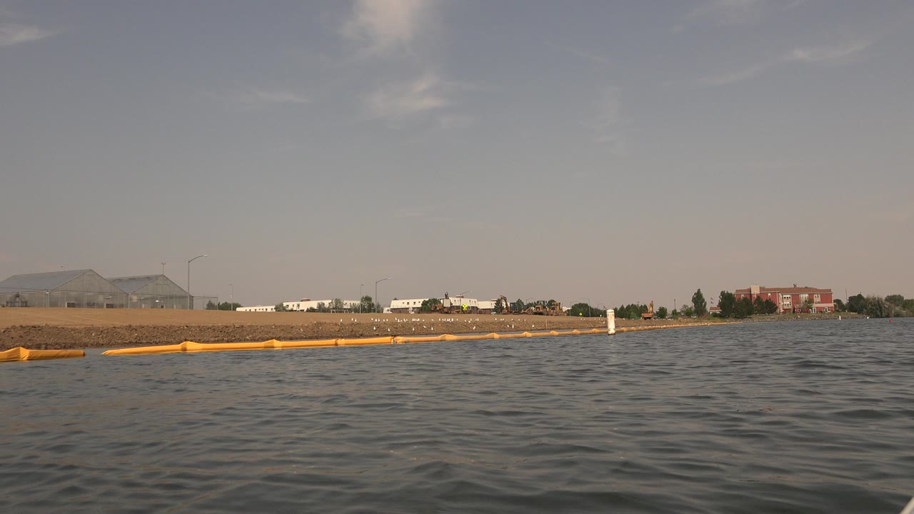 Water-level lake view with yellow boom along the shoreline