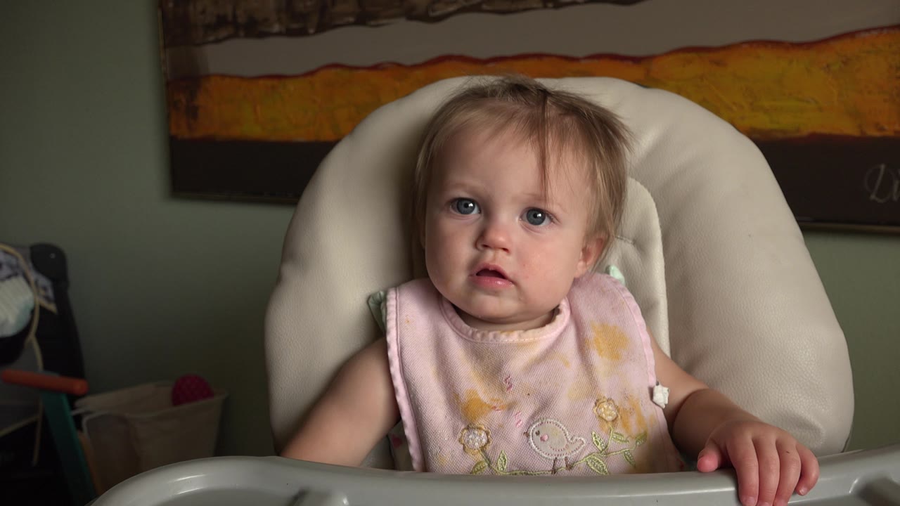 Baby in highchair looking slightly upward