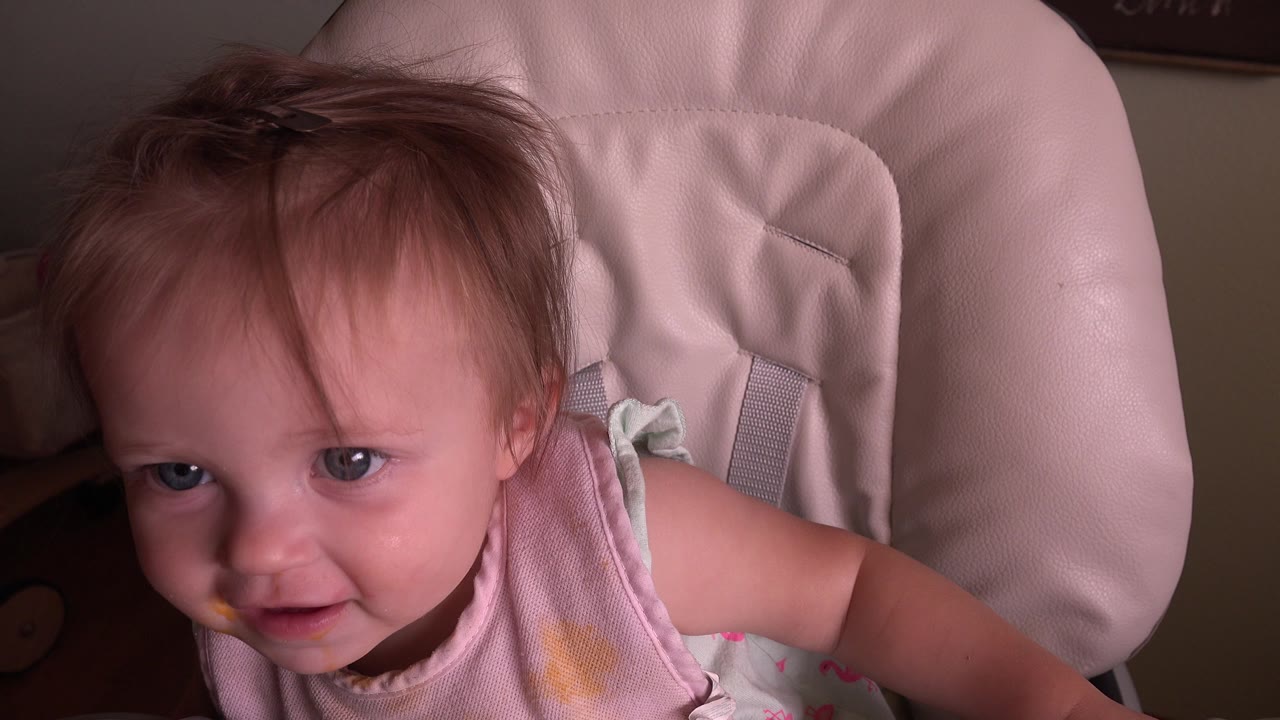 At Hidden Lake, Colorado, the baby leans forward in the pale chair, with messy hair, blue eyes, and food marks visible in the close frame.