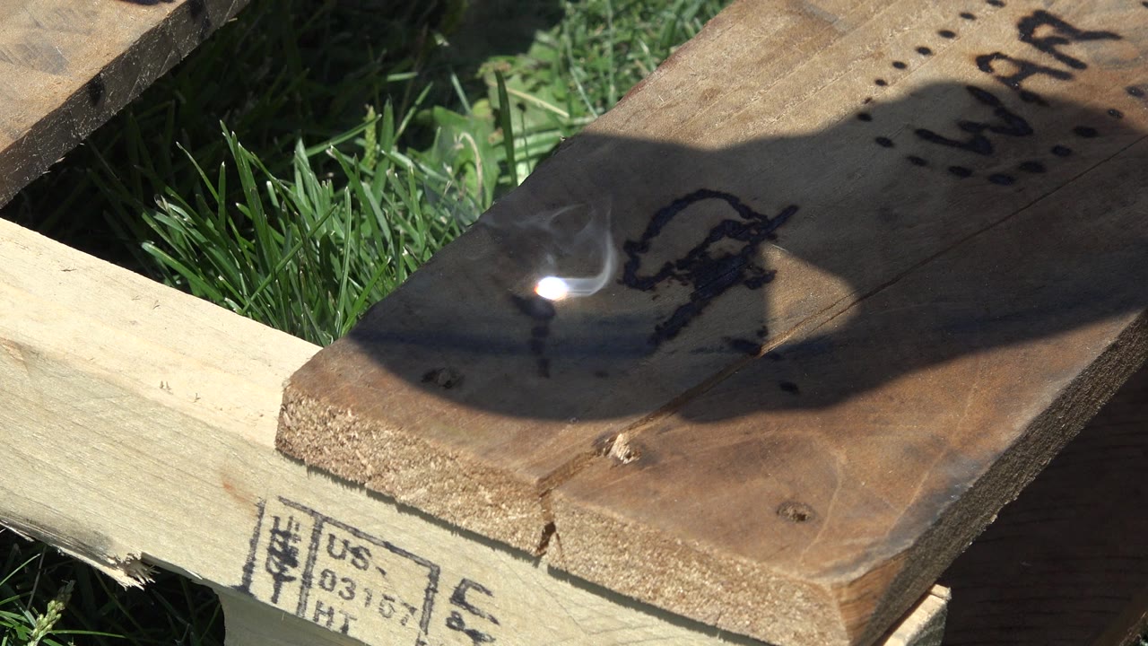 Bright sunlight spot on charred wood over grass