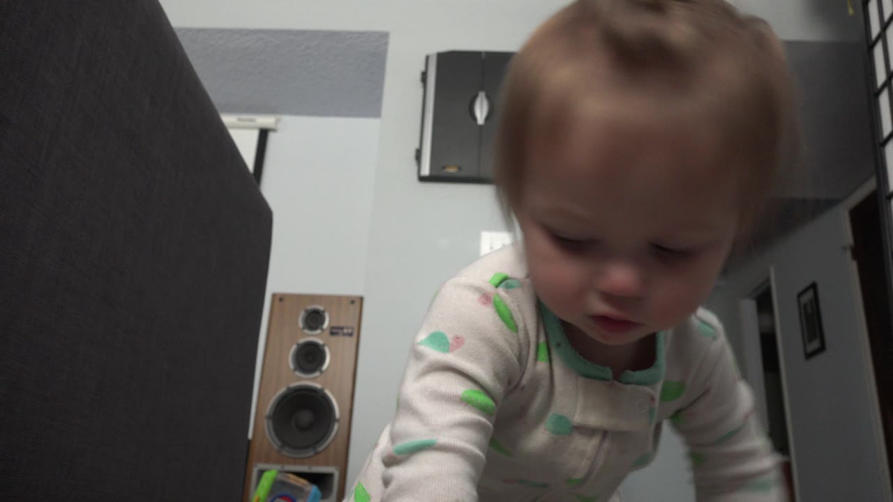 Baby looking downward while crawling near the camera.