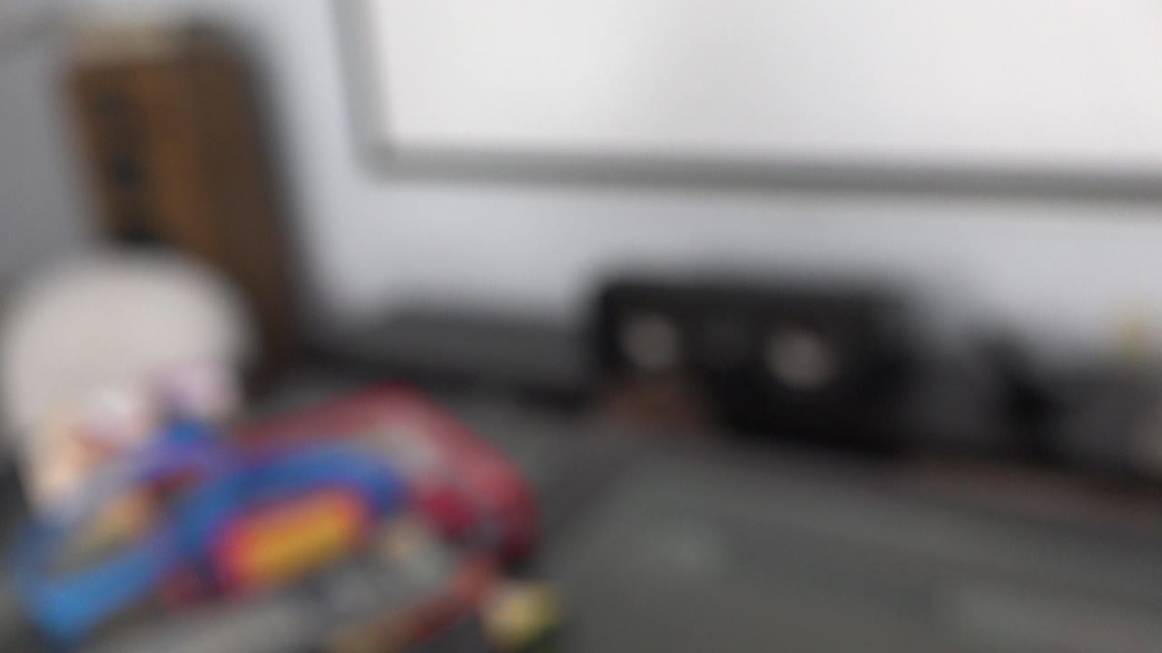 Blurred living room view with tabletop objects and a media console.