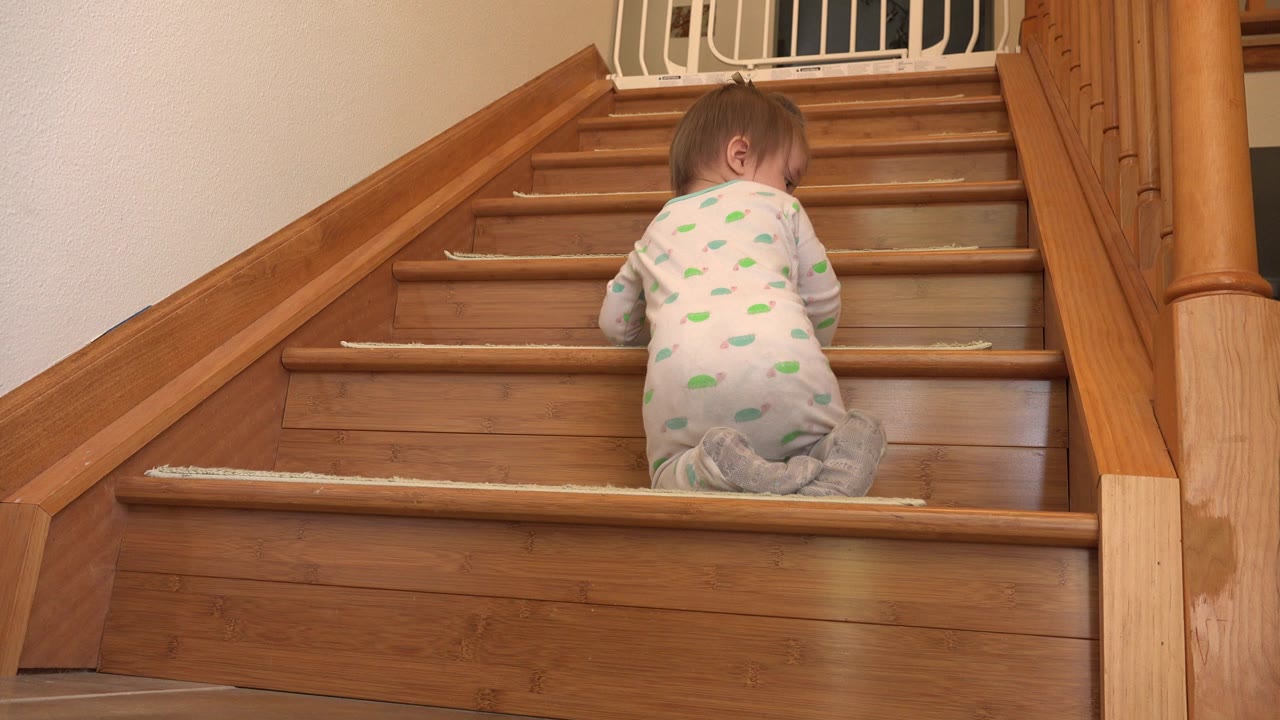 Baby facing up the stairs with back toward camera.