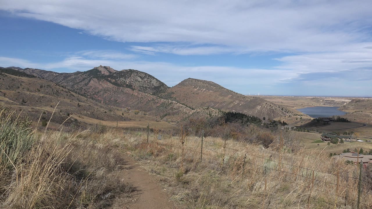 Mountain valley with trail foreground and lake to the right