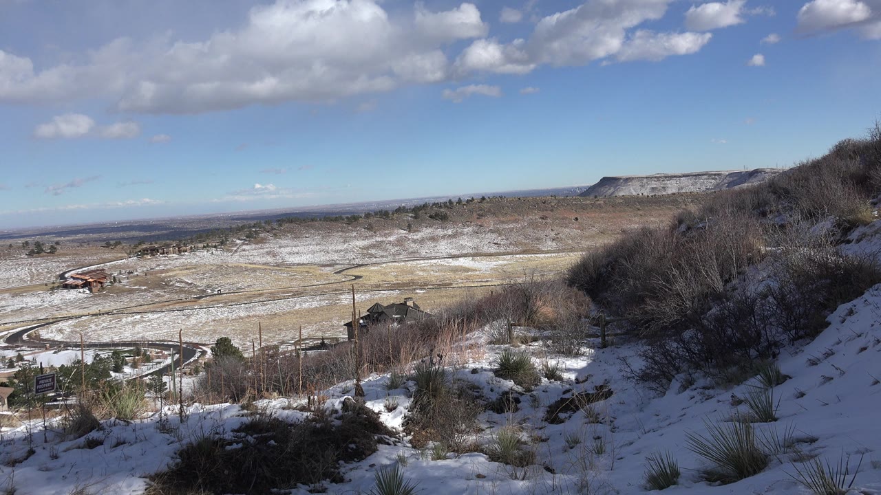 Third frame shows the same Golden, Colorado winter overlook with the foreground slope in shadow, pale fields below, flat-topped ridges on the horizon, and no visible people.
