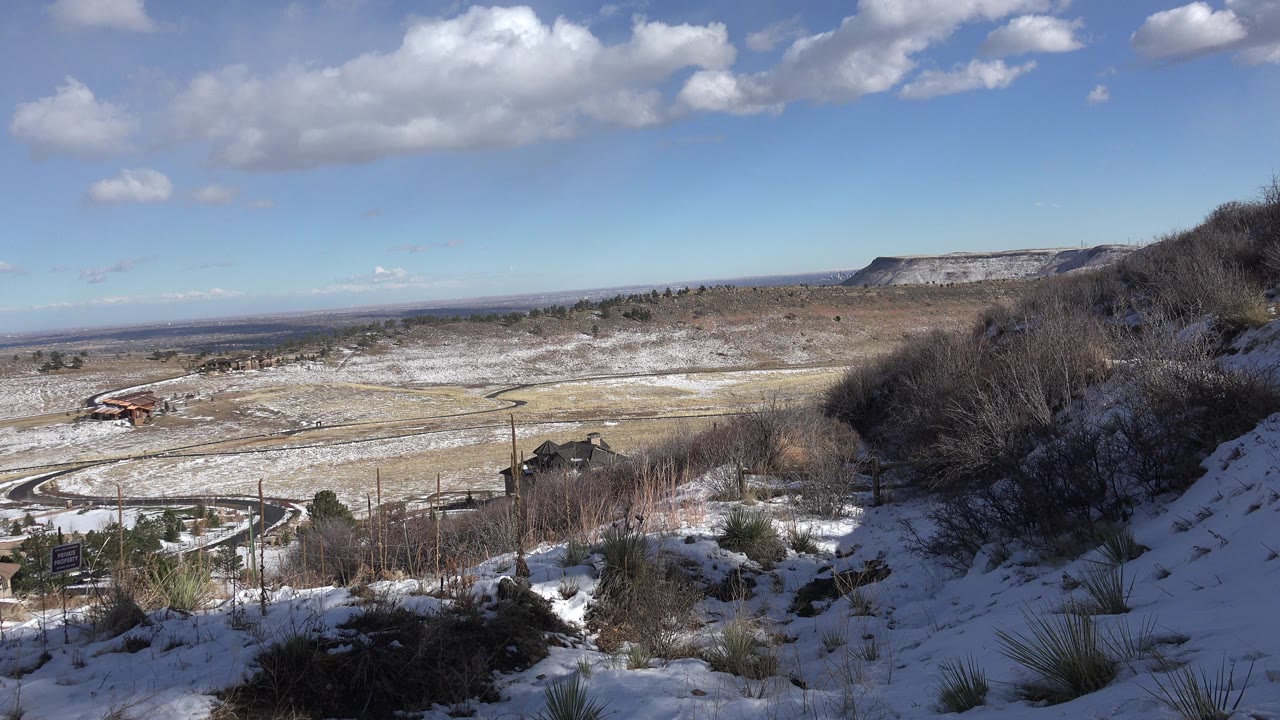 Snowy hillside overlook above a dry valley and distant ridge