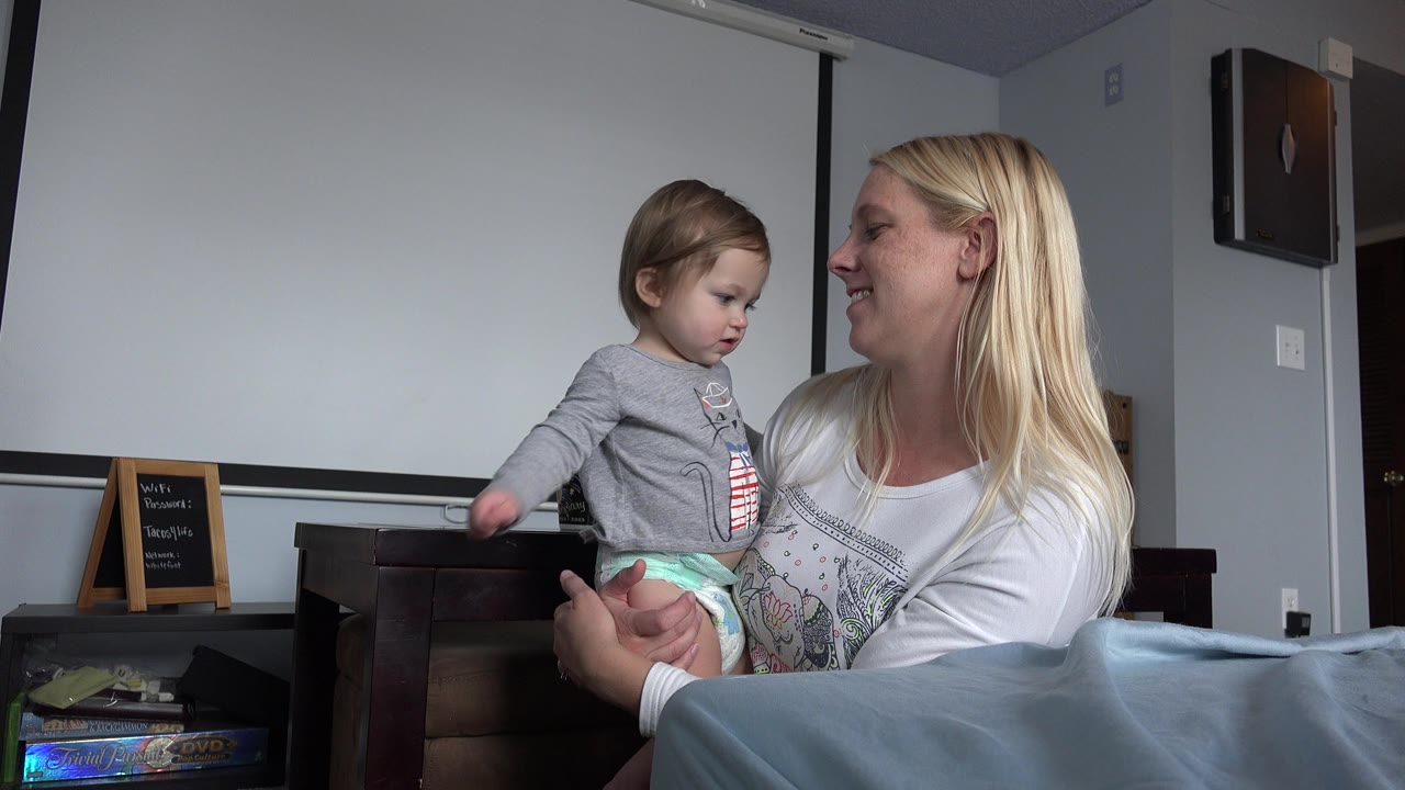 Woman holding a toddler in a bedroom