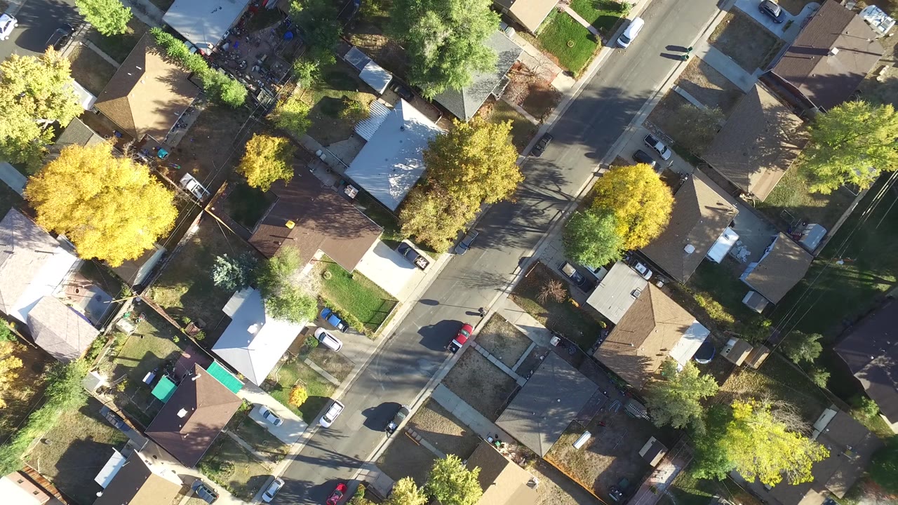 Top-down neighborhood blocks with roofs, trees, streets, and cars.
