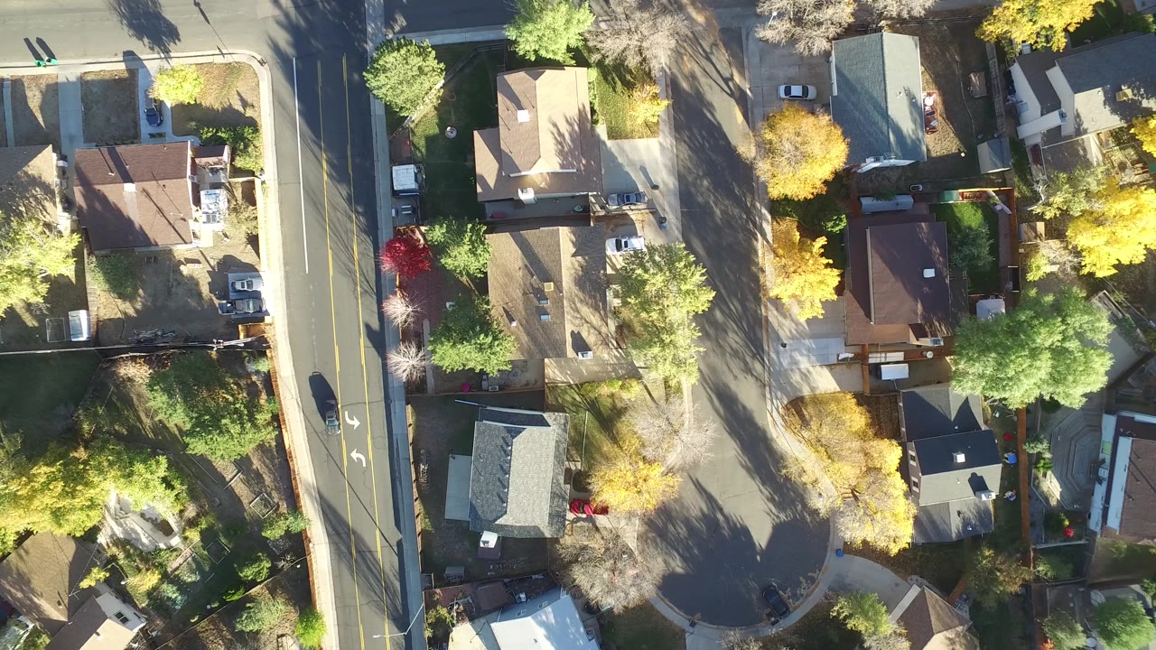 Overhead view of houses, a road, and autumn trees