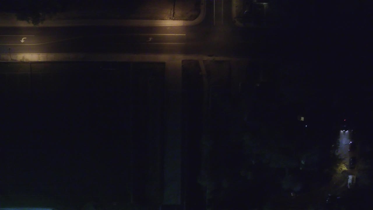 High night view in Hidden Lake, Colorado showing lit road edges, a dark roof block across the lower frame, scattered lights, and no visible people.