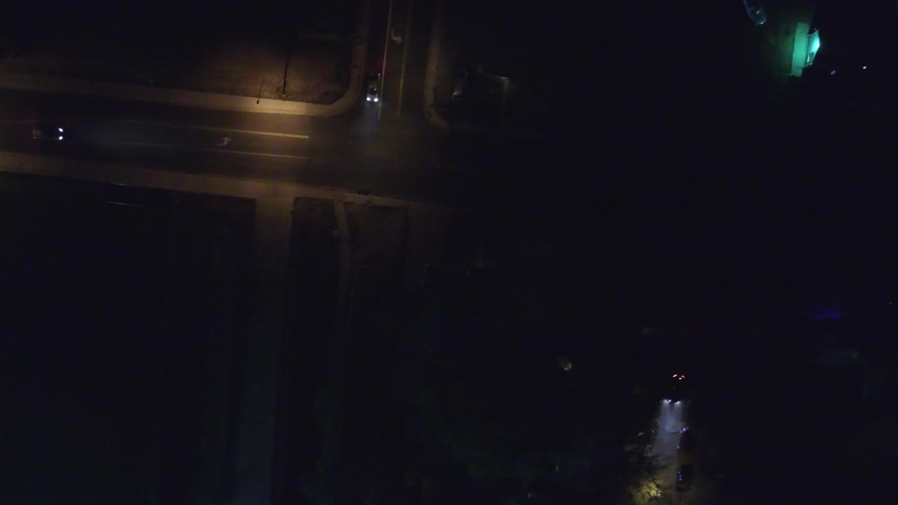Overhead dark street corner lit by amber lamps