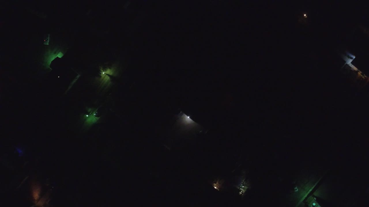 A second dark Hidden Lake, Colorado aerial frame shows separated green, amber, and white light points across barely visible homes or paths, with no visible people.