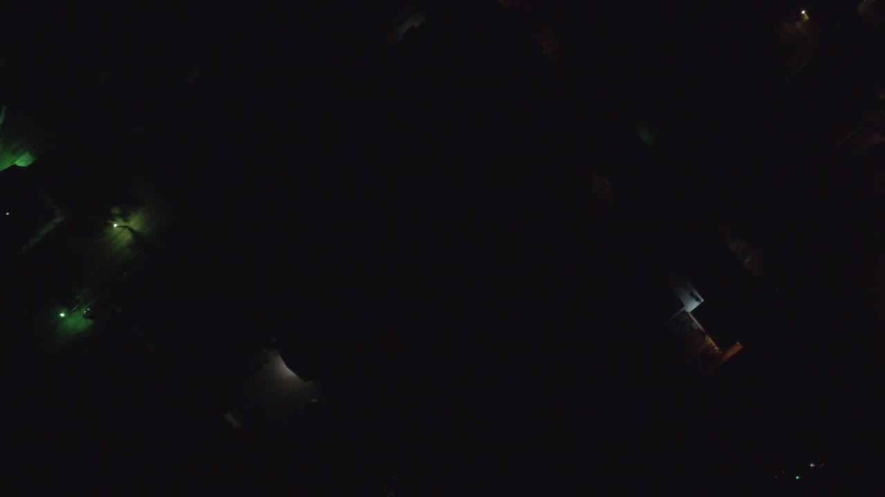 Overhead night frame in Hidden Lake, Colorado showing isolated green and amber lights across mostly black residential blocks, with no visible people.