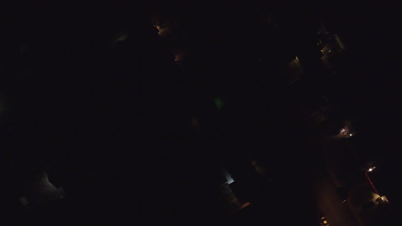 Mostly black aerial-looking frame over Hidden Lake, Colorado with a few isolated amber lights and indistinct built shapes, no visible people.