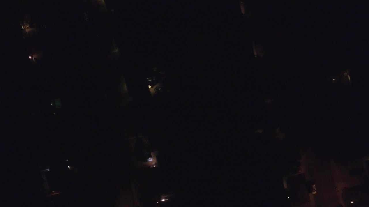 Very dark overhead neighborhood view with scattered small lights.