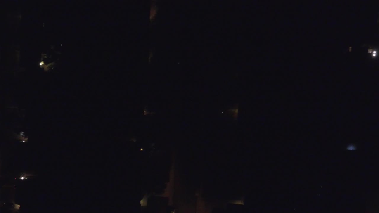 Very dark aerial view with scattered lights
