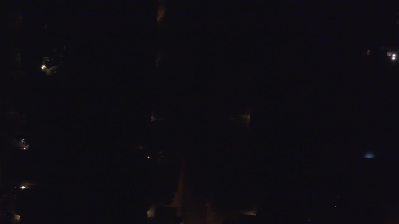 Sparse points of light appear across a nearly black aerial view of Hidden Lake, Colorado, with faint street geometry and no visible people.