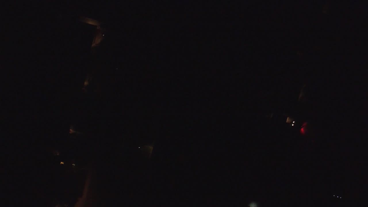 Very dark night frame with a few small warm lights.