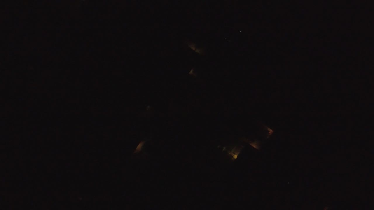 At 0:01, the Hidden Lake, Colorado aerial remains mostly black, with a small group of warm lights slightly lower in the frame and no visible people.