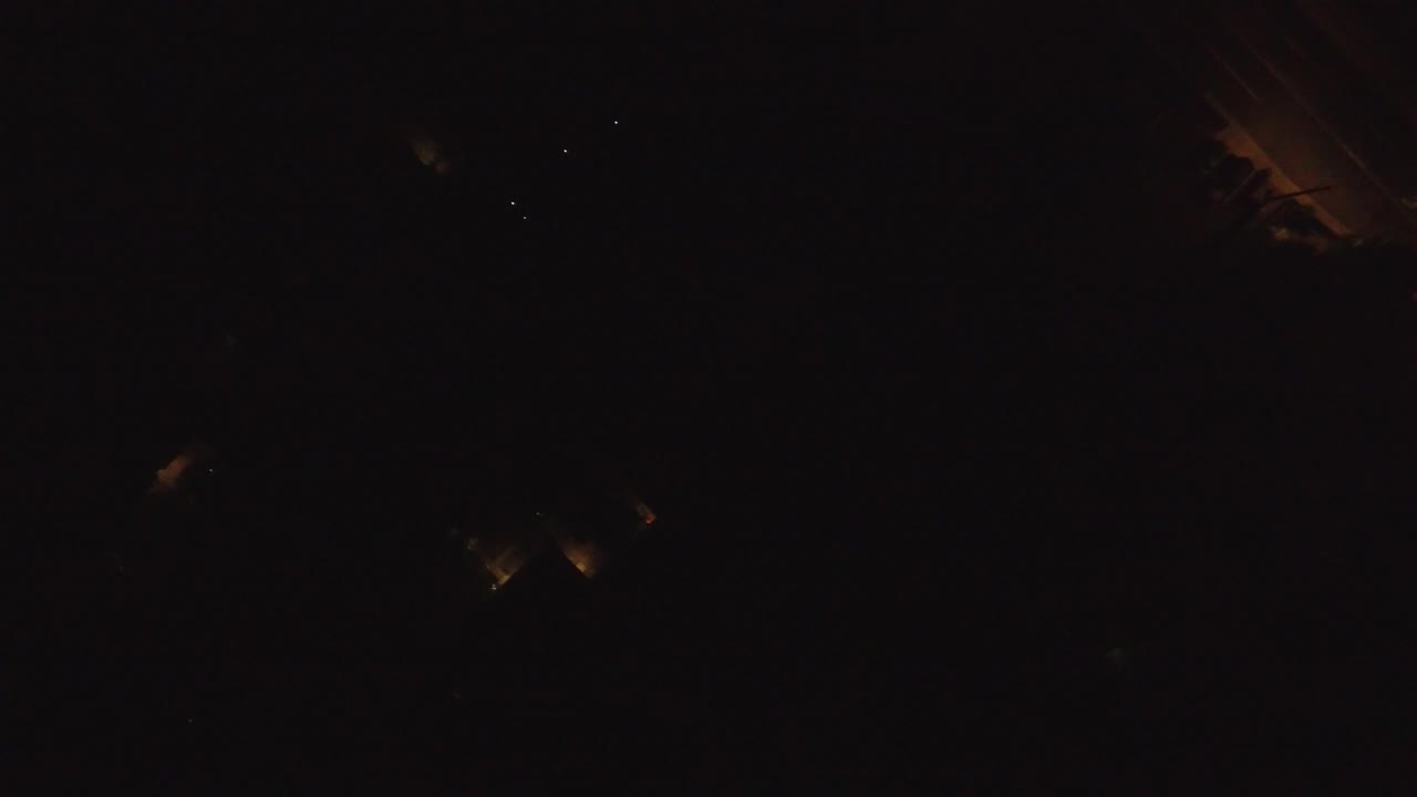 Almost black aerial view with a dim orange lit strip near the upper right.