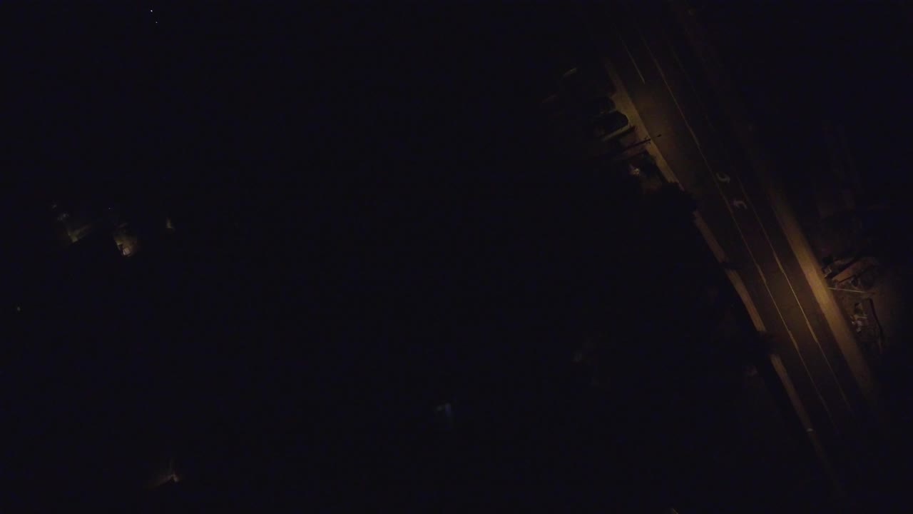 Very dark overhead road with amber streetlights.