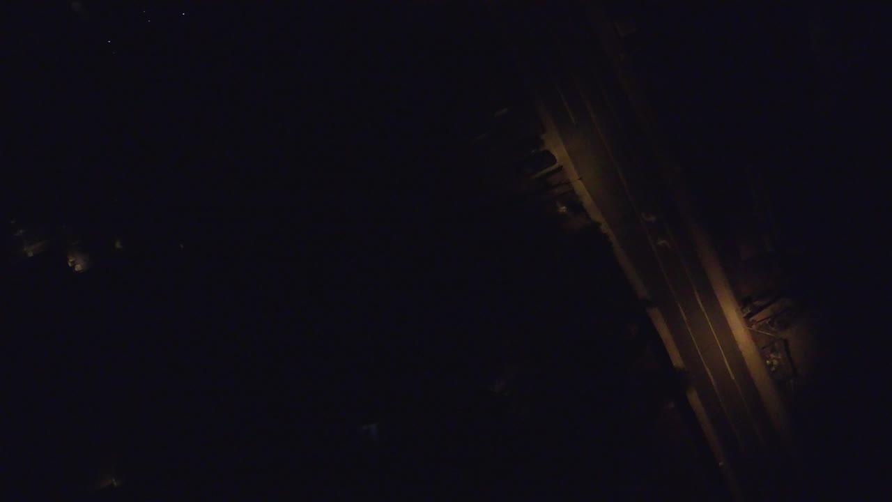 Dark overhead street with amber lamps and faint buildings.