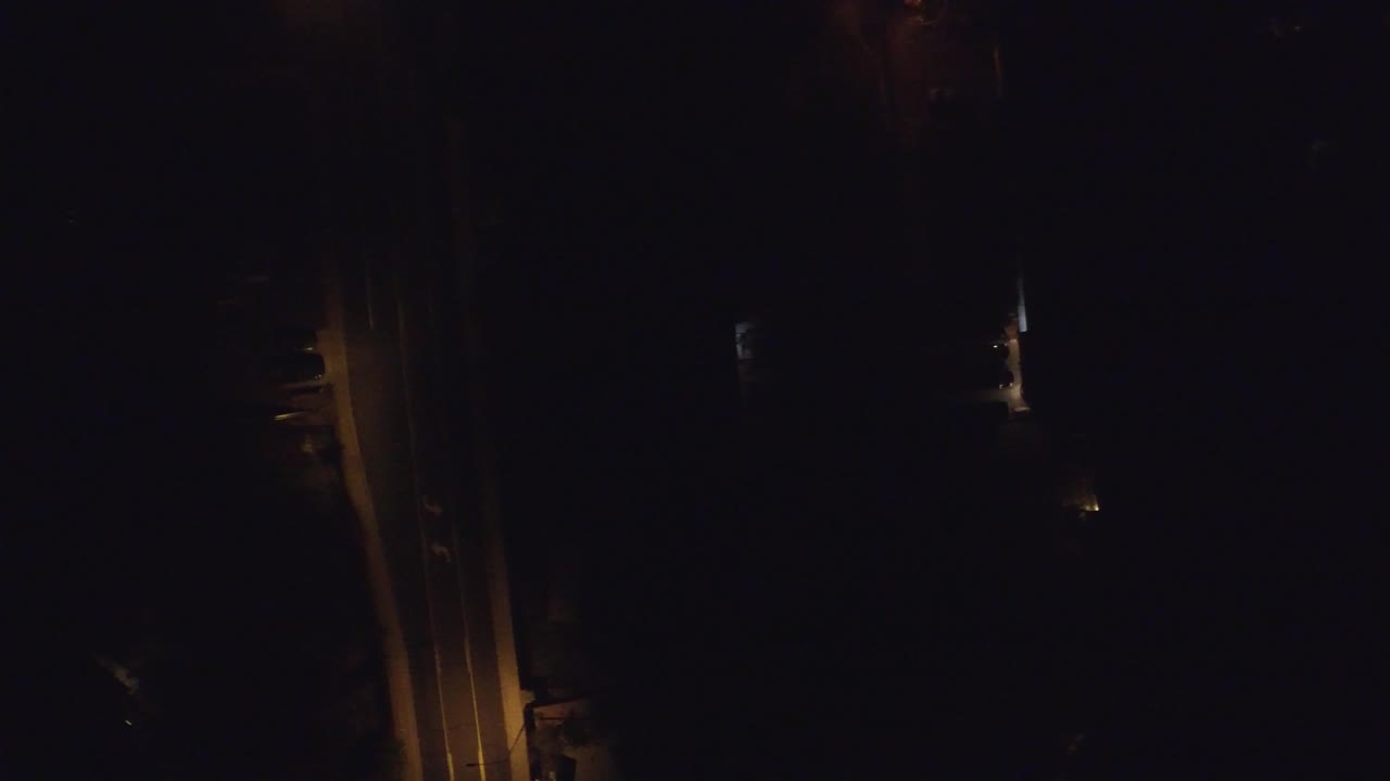 Dark frame with faint amber strip and small white light points.