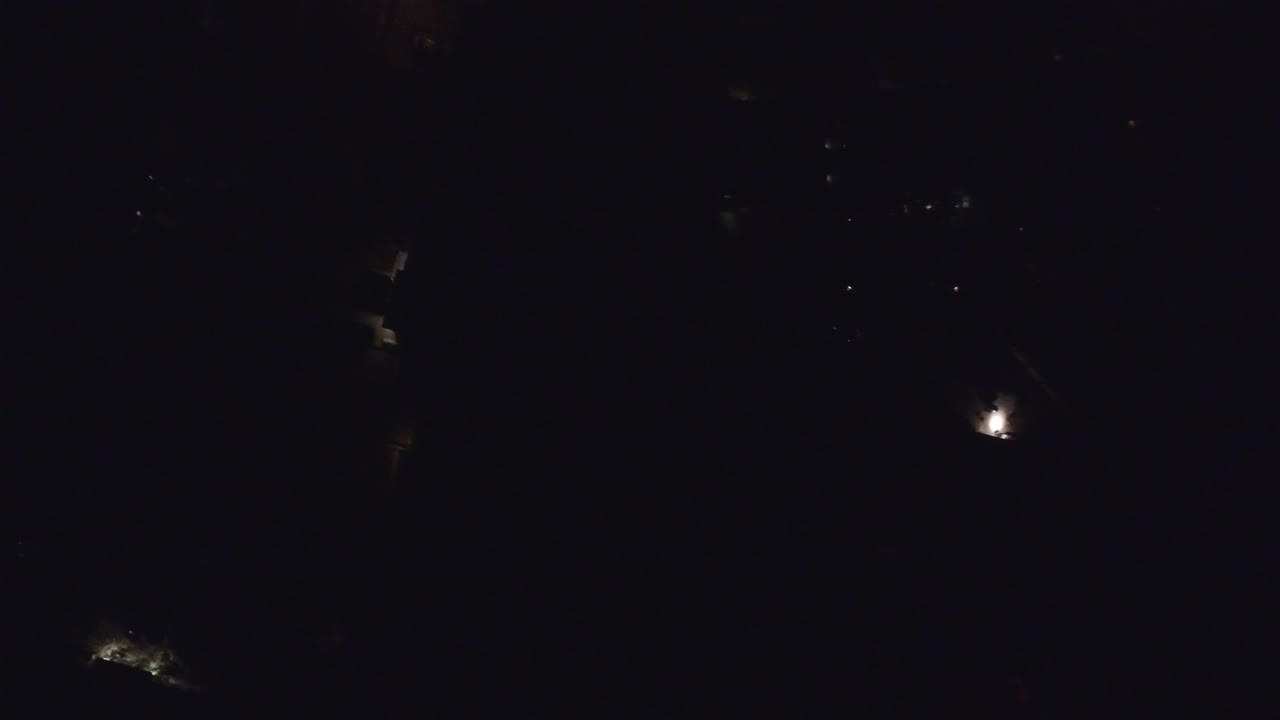 A dark Hidden Lake, Colorado night view with one brighter white light right of center, faint surrounding darkness, and no visible people.