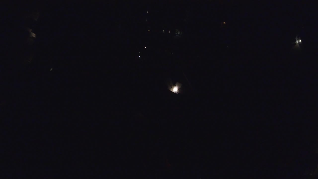 Dark sky with a bright point near the lower portion and faint specks above.
