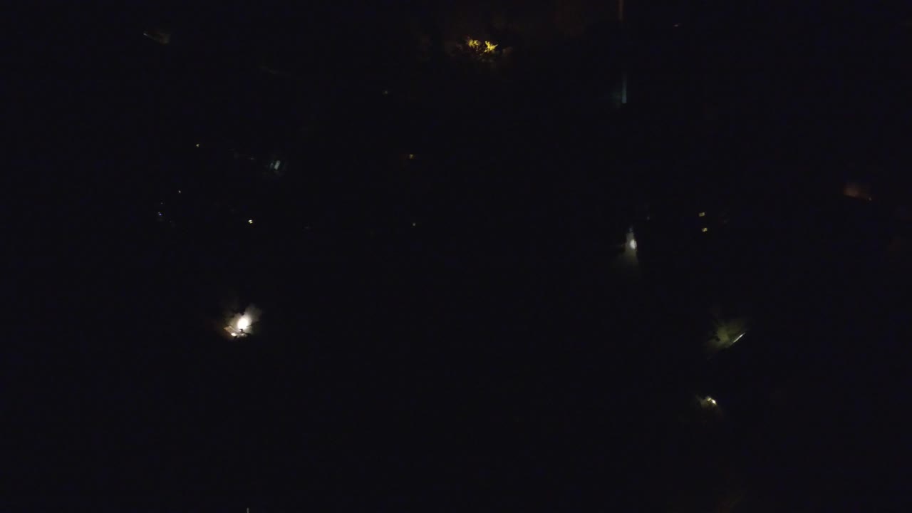 Dark aerial night view with scattered small lights
