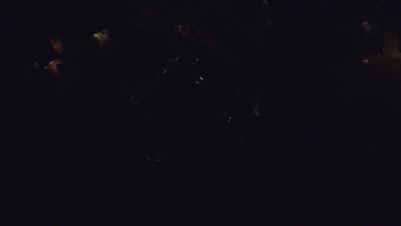 Hidden Lake, Colorado aerial frame at 0:01, showing a mostly black scene with tiny light sources and no visible people.