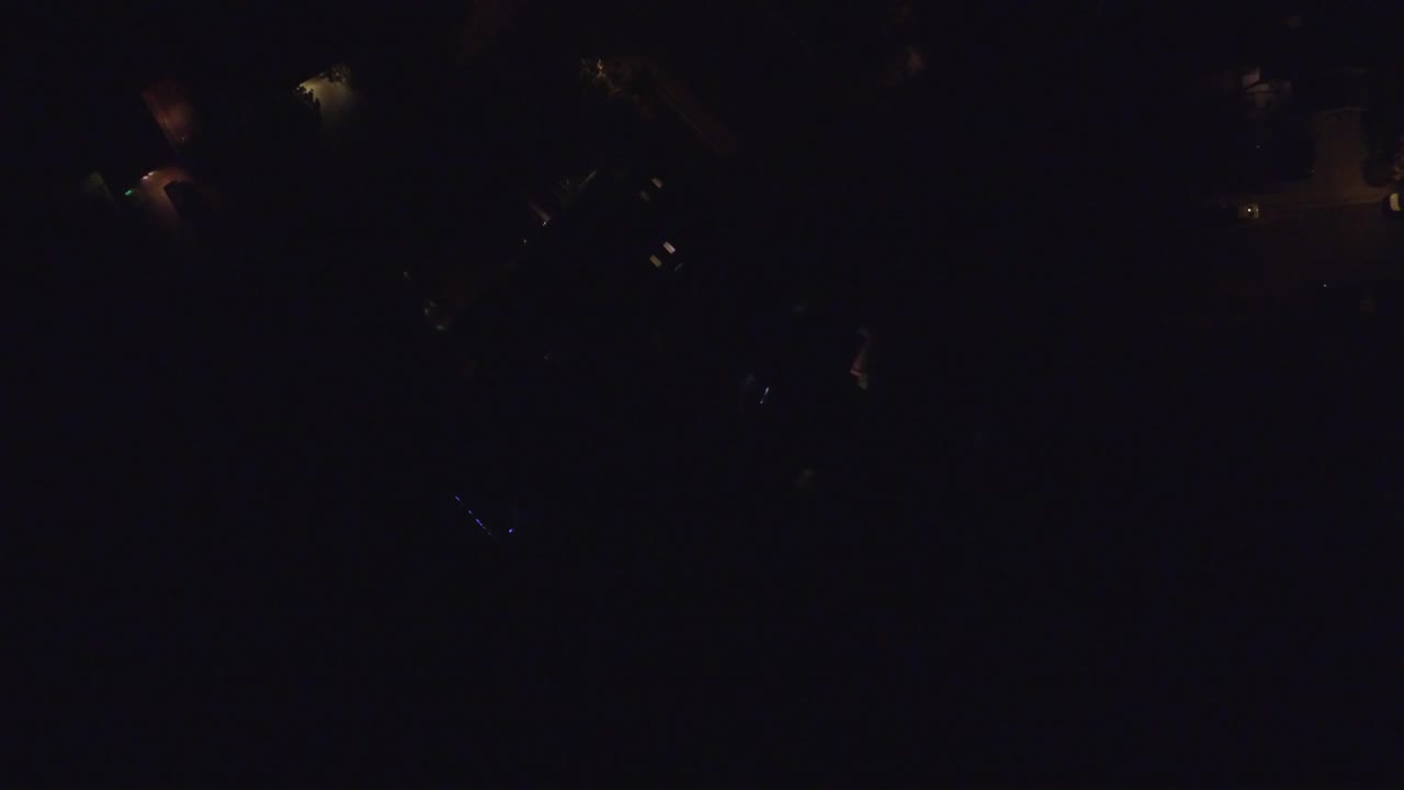 Dark aerial view with a small illuminated patch near the upper frame.
