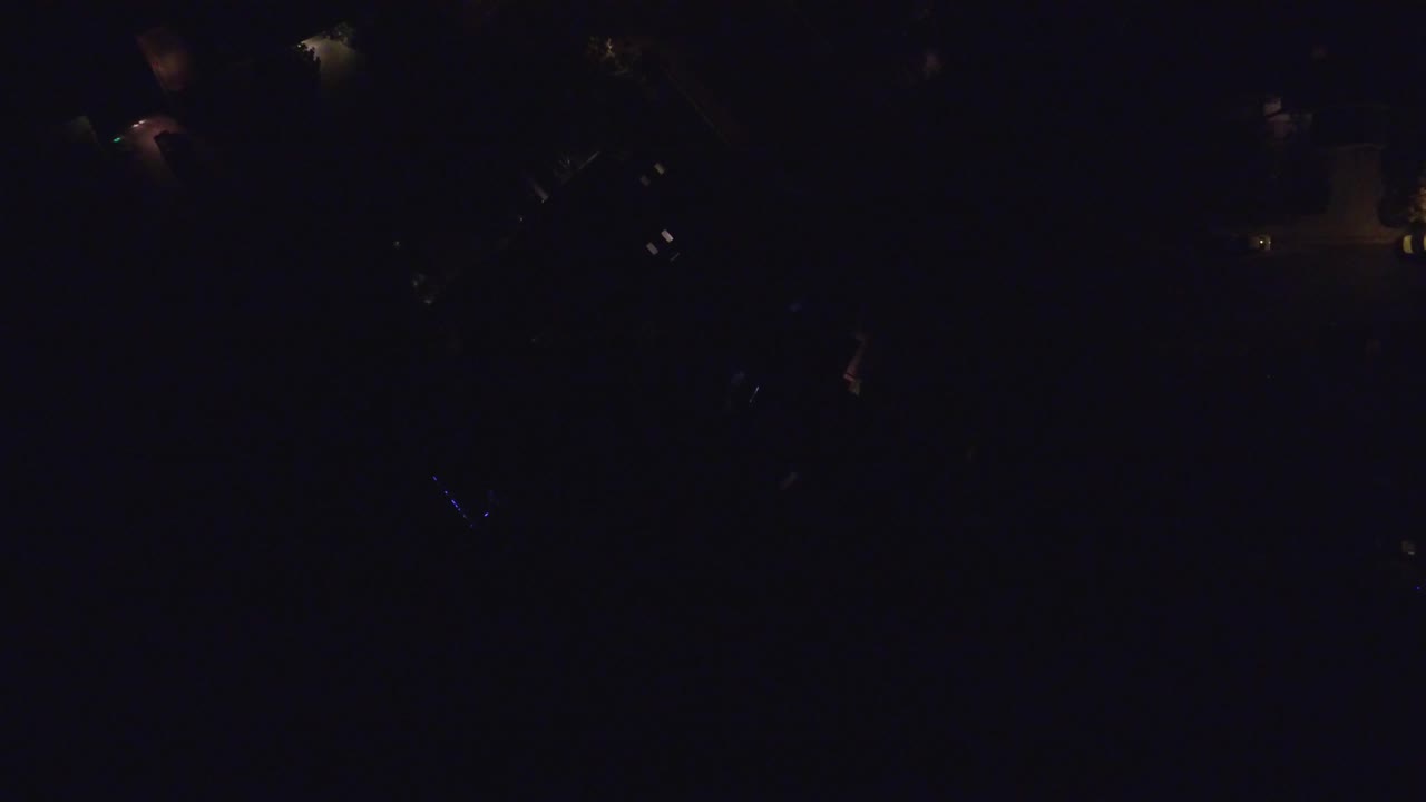 Dark aerial view with scattered warm residential lights