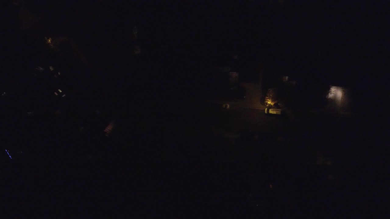 Dark overhead frame of Hidden Lake, Colorado with small warm house and street lights visible across mostly black residential blocks, no visible people.