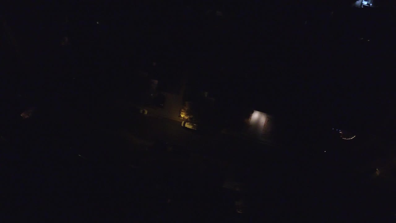 Very dark aerial view with scattered building and street lights.