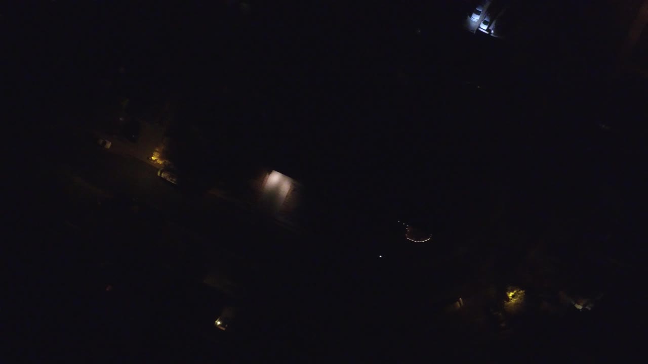 Dark overhead view in Hidden Lake, Colorado with scattered warm streetlights, faint building shapes, and no visible people.
