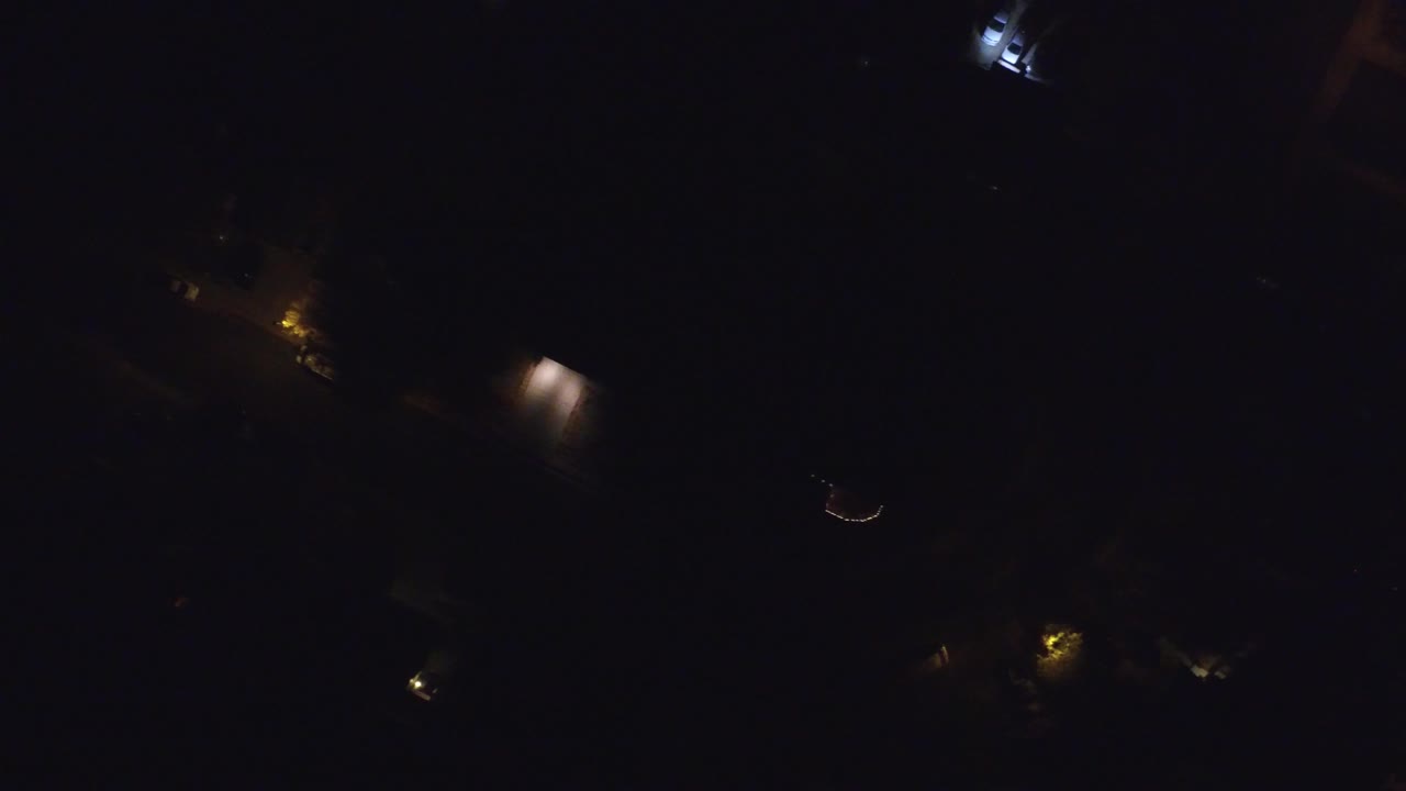 Very dark residential road with isolated light pools