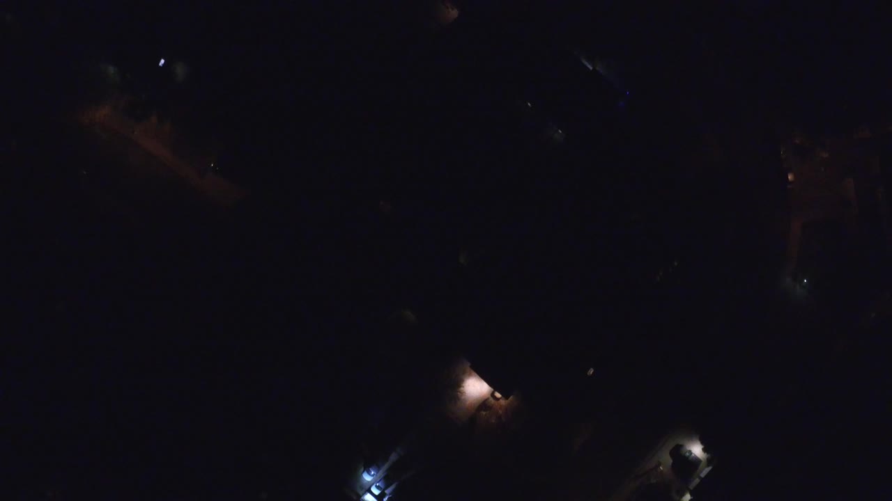 Very dark aerial view with a few small lights