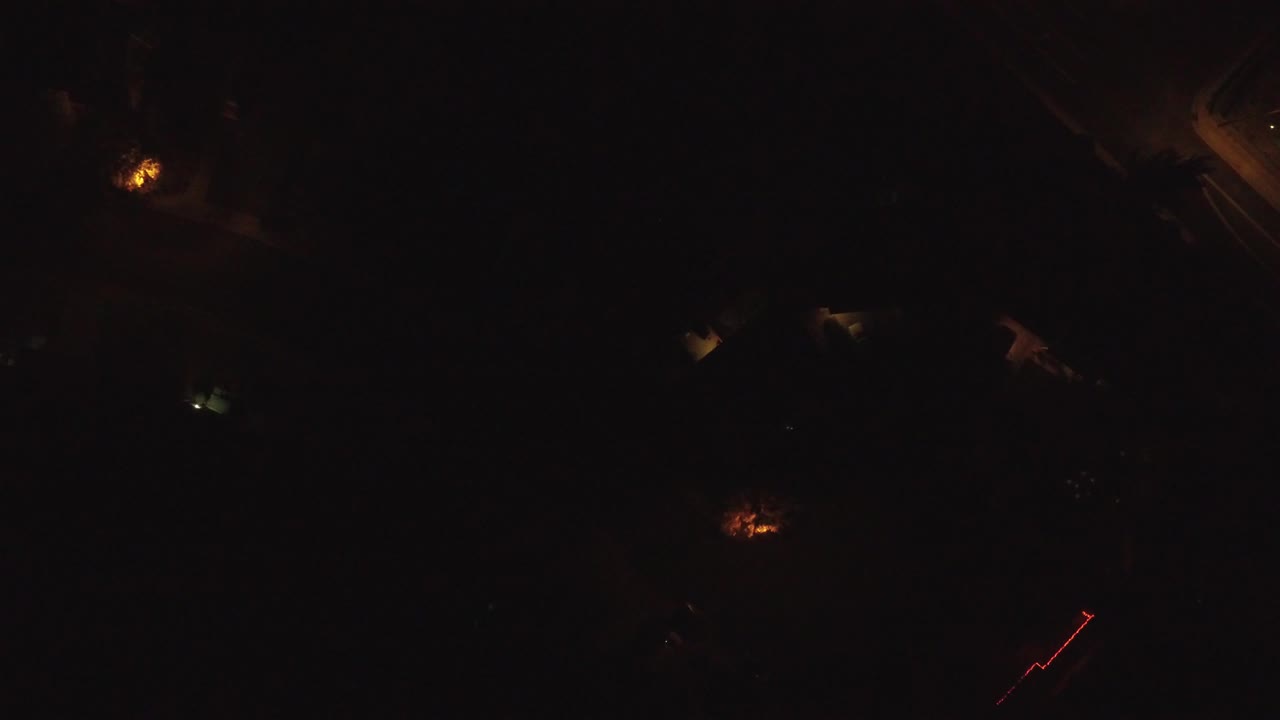Very dark aerial frame over Hidden Lake, Colorado, with scattered orange and white ground lights and no visible people.